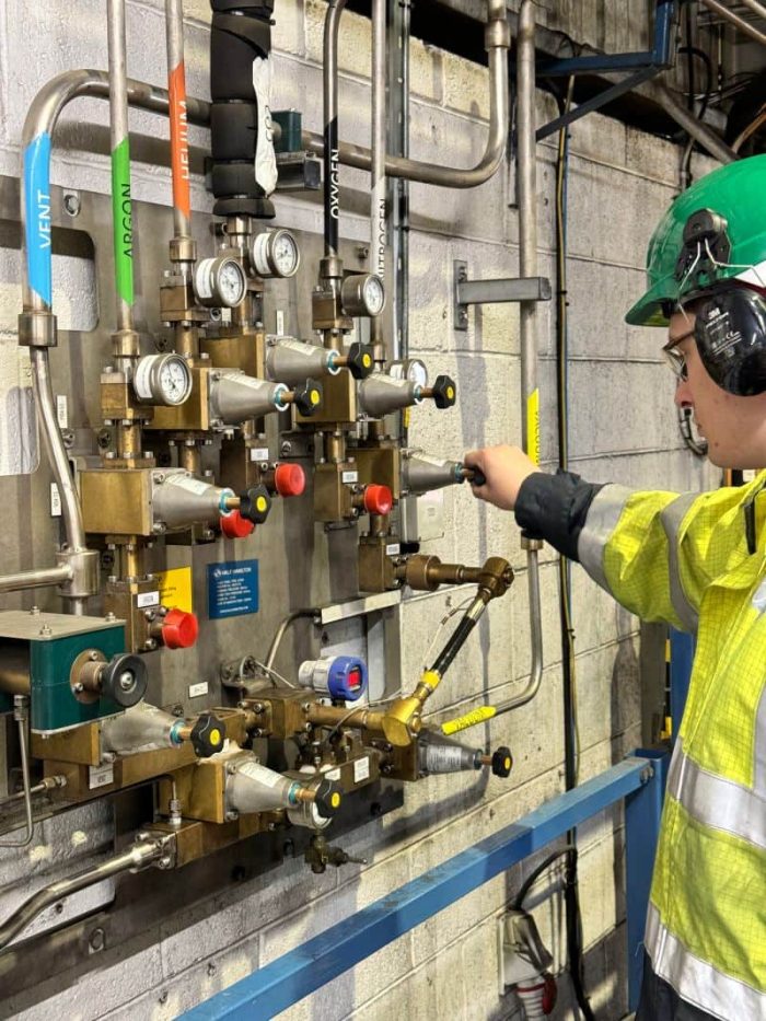 IGAS engineer carrying out industrial gas system inspection and valve adjustment on site